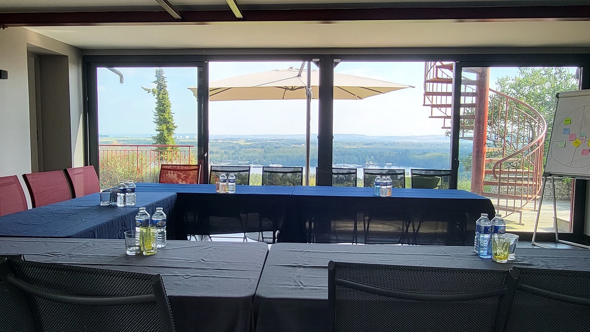 Salle plénière installée en U, baies vitrées sur la vallée
